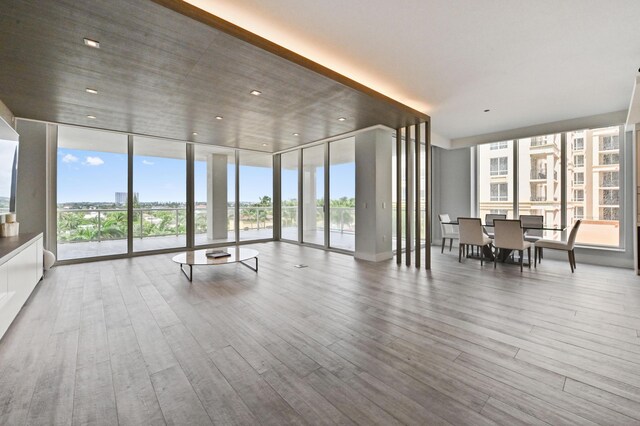 dining area featuring a healthy amount of sunlight, wine cooler, and light hardwood / wood-style flooring