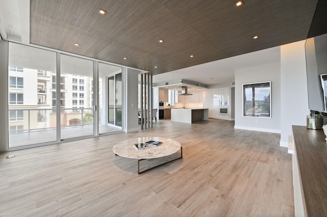 living room featuring light wood-type flooring and a wall of windows