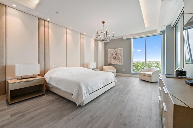 bedroom featuring light hardwood / wood-style flooring, floor to ceiling windows, and a notable chandelier