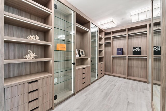 bedroom with light wood-type flooring, an inviting chandelier, and access to outside