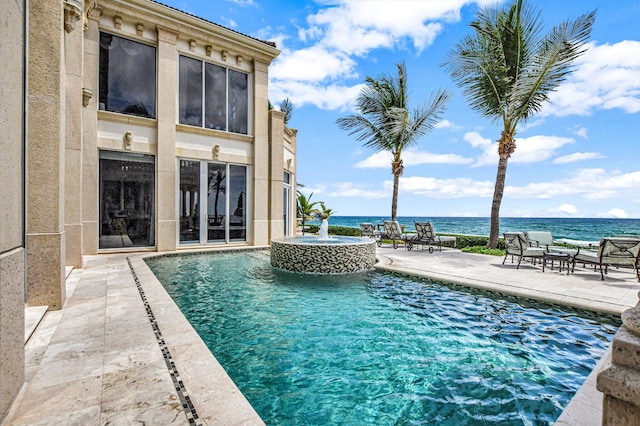 view of swimming pool featuring an in ground hot tub, a water view, and a patio area