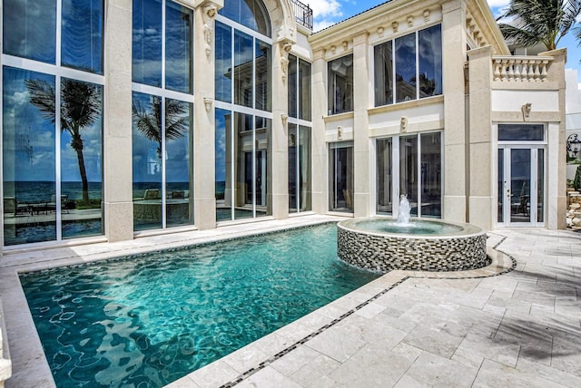 view of pool featuring a patio, an in ground hot tub, and pool water feature