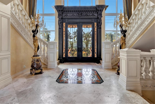 foyer entrance featuring french doors and a towering ceiling