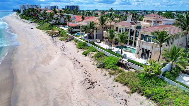 birds eye view of property with a water view and a beach view