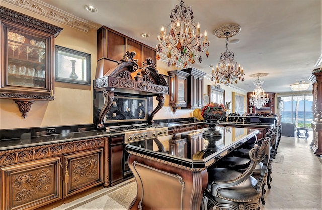 kitchen featuring crown molding, gas range, a kitchen island, and a notable chandelier