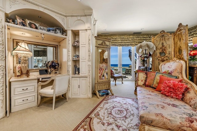 bedroom featuring light carpet, built in desk, and access to outside