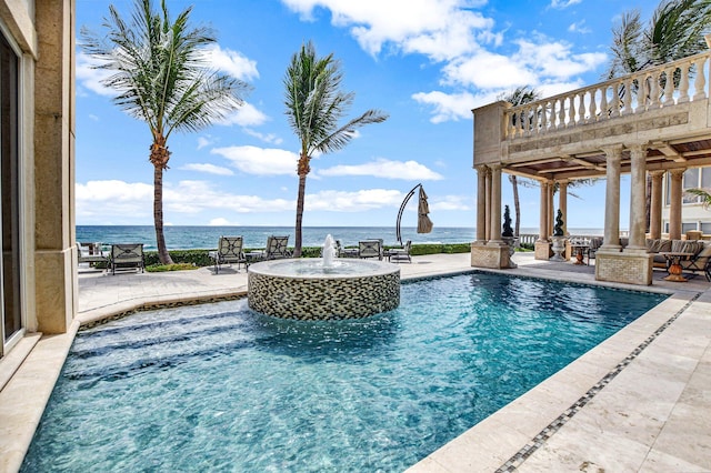 view of pool with a patio area, a water view, and pool water feature