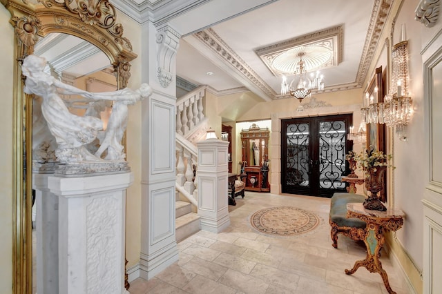 entrance foyer featuring an inviting chandelier, french doors, and crown molding