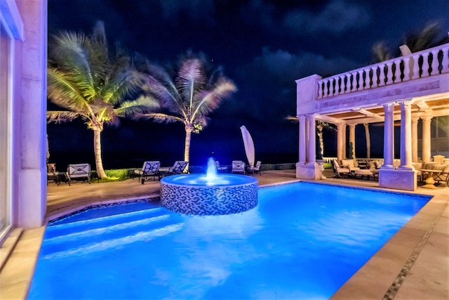 pool at twilight featuring a patio area