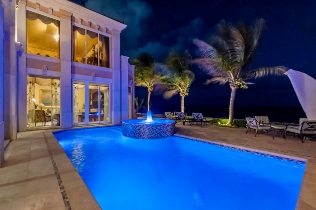 pool at twilight featuring a patio