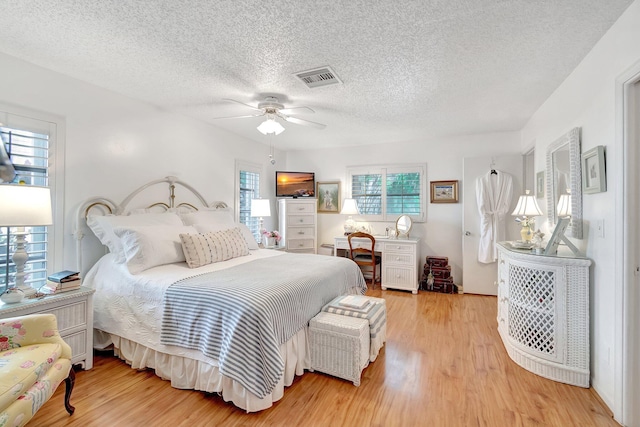 bedroom with ceiling fan, light hardwood / wood-style flooring, and multiple windows