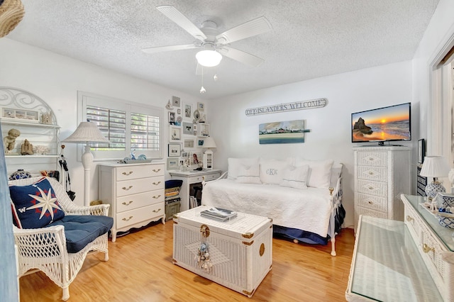 bedroom featuring a textured ceiling, ceiling fan, and light hardwood / wood-style flooring