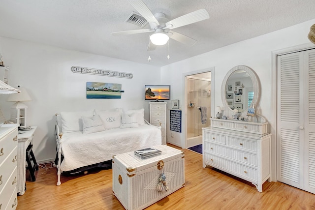 bedroom with ceiling fan, light wood-type flooring, a closet, and a textured ceiling