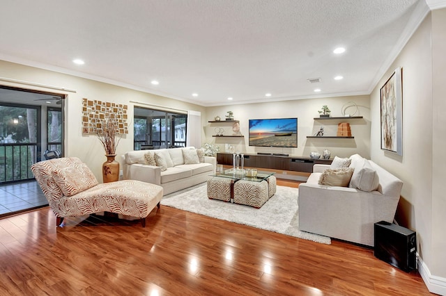 living room with a wealth of natural light, ornamental molding, and hardwood / wood-style floors