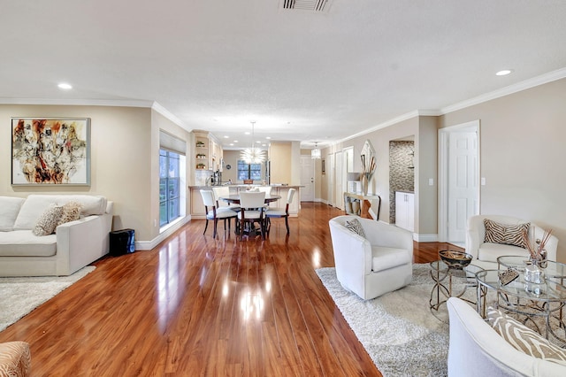 living room with ornamental molding and hardwood / wood-style floors