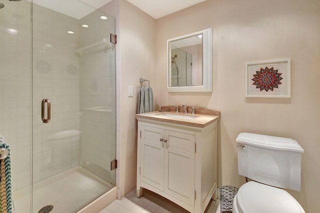 bathroom featuring a shower with door, vanity, toilet, and tile patterned flooring