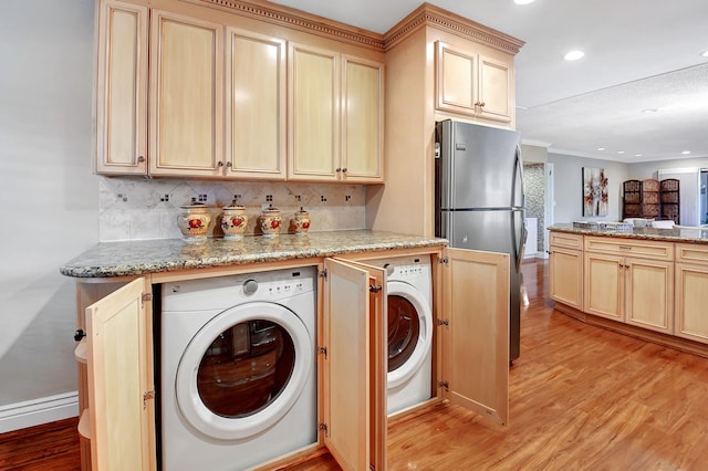 clothes washing area with crown molding, washer / dryer, indoor bar, and light hardwood / wood-style floors