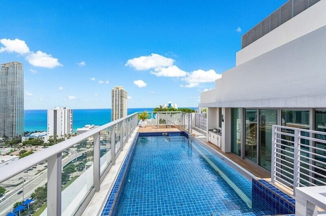 view of pool with a water view and a view of city