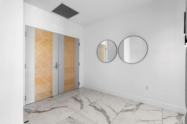 unfurnished room featuring visible vents, baseboards, and marble finish floor