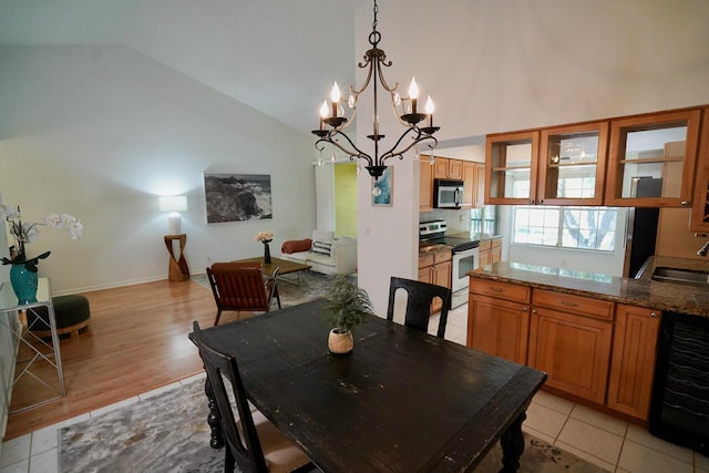 2121 S Ocean Blvd Unit 804, Lauderdale By The Sea, FL 33062 - dining room with beverage cooler, a chandelier, light wood-style floors, and high vaulted ceiling