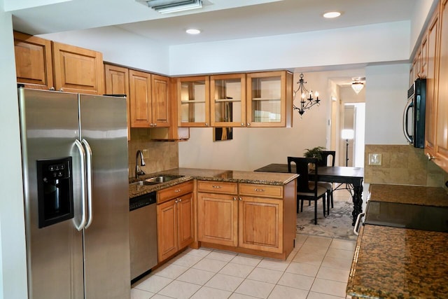 2121 S Ocean Blvd Unit 804, Lauderdale By The Sea, FL 33062 - kitchen featuring black appliances, a peninsula, light tile patterned floors, glass insert cabinets, and dark stone counters