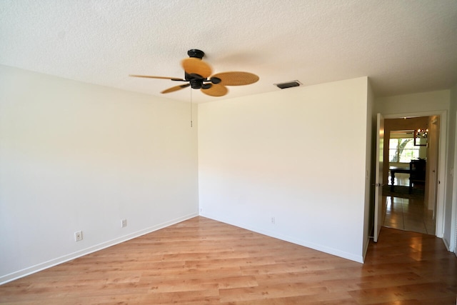 empty room featuring ceiling fan, a textured ceiling, and light hardwood / wood-style flooring