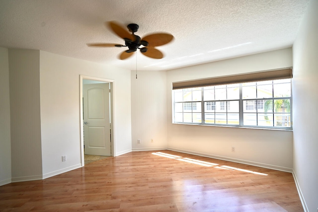 empty room with a textured ceiling, light hardwood / wood-style floors, and ceiling fan