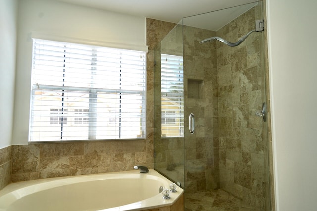 bathroom featuring shower with separate bathtub