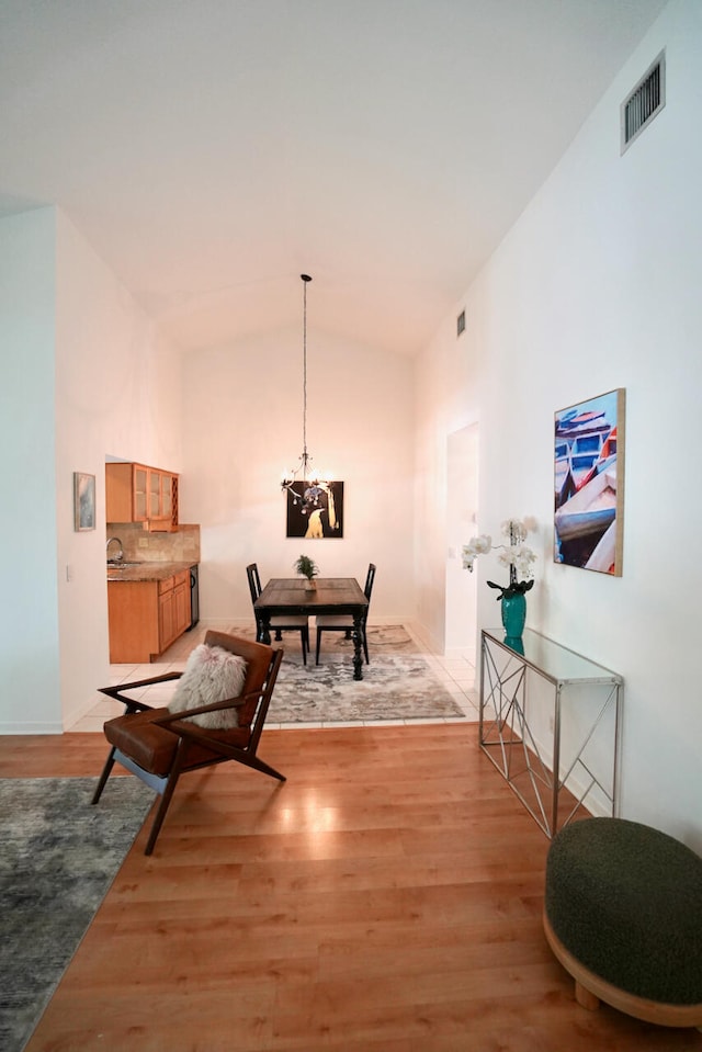 living area with light hardwood / wood-style flooring and high vaulted ceiling