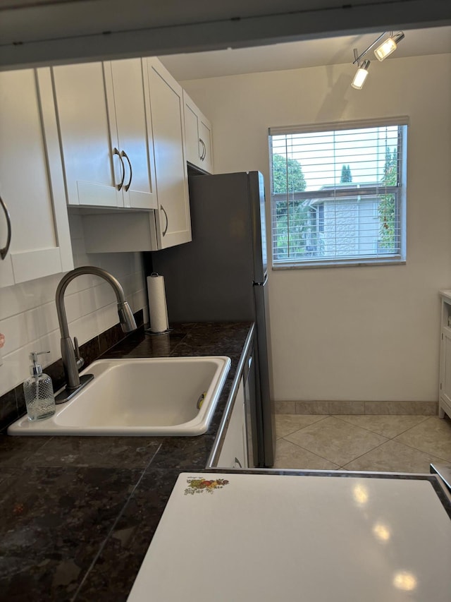 kitchen featuring sink, white cabinets, and decorative backsplash