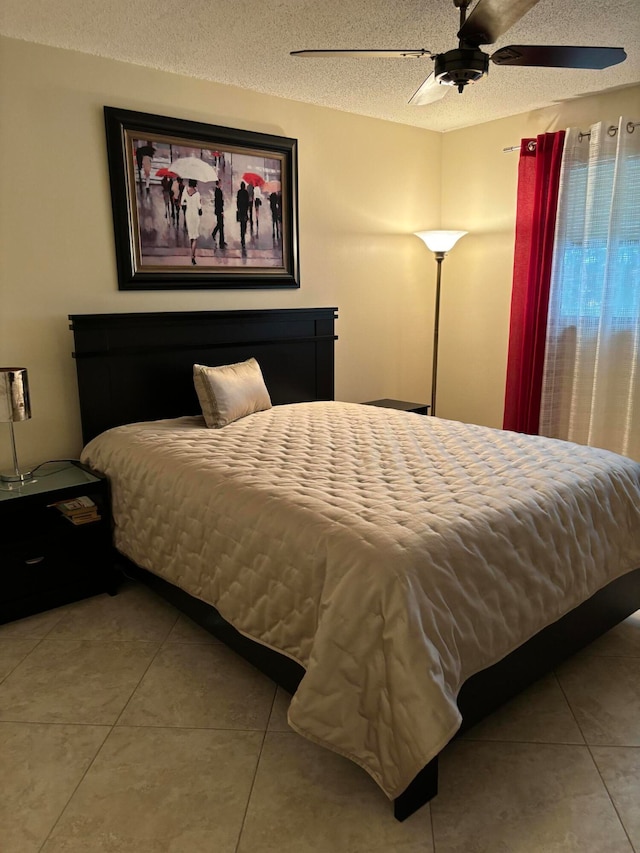 tiled bedroom with a textured ceiling and ceiling fan