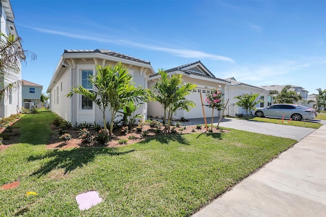 view of front facade with a front yard, a garage, and central AC unit