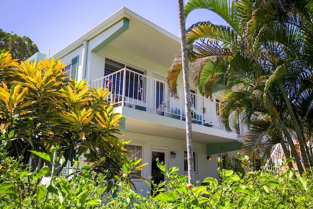 exterior space with stucco siding and a balcony