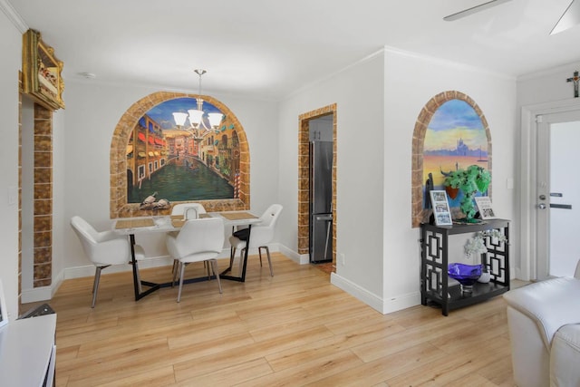 dining room with ornamental molding, ceiling fan with notable chandelier, baseboards, and wood finished floors