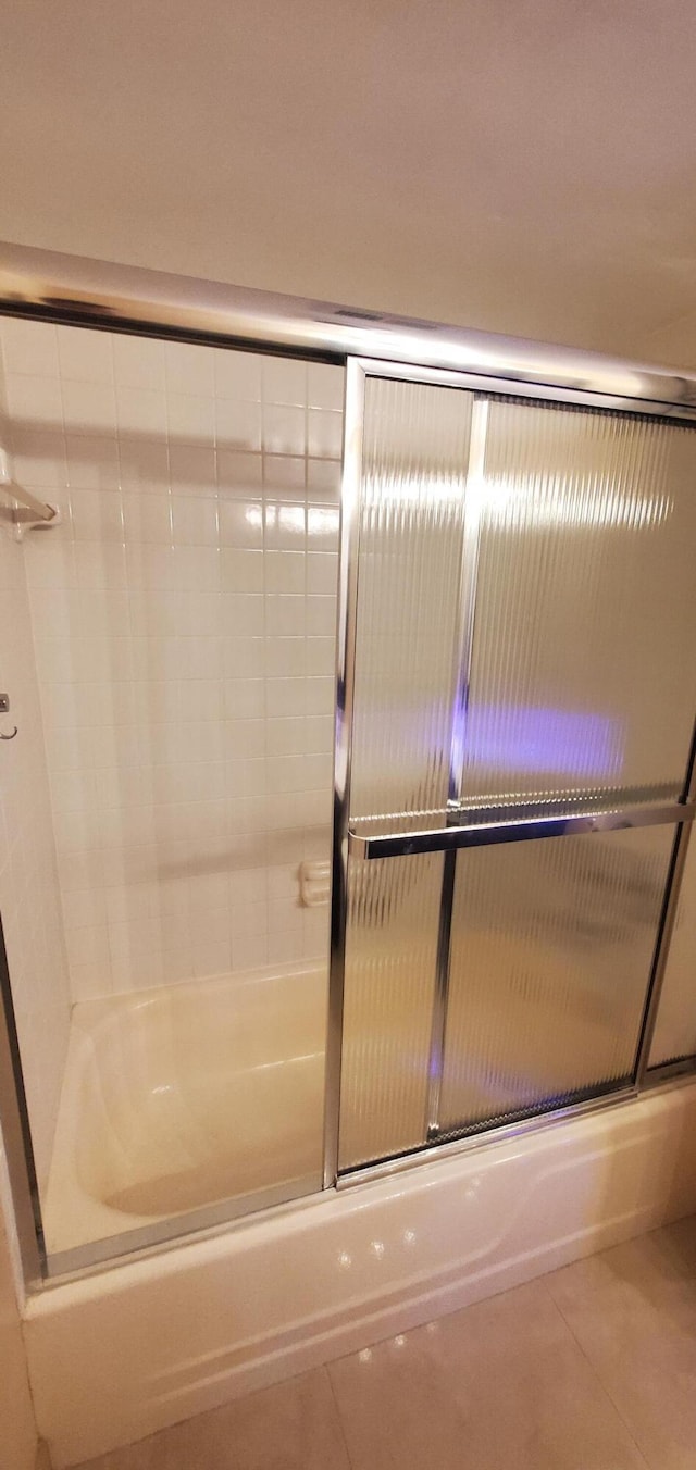 bathroom featuring shower / bath combination with glass door and tile patterned floors