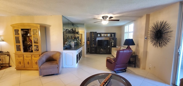 tiled living room with ceiling fan and a textured ceiling