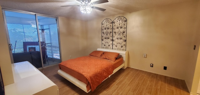 bedroom featuring ceiling fan, hardwood / wood-style flooring, and a textured ceiling