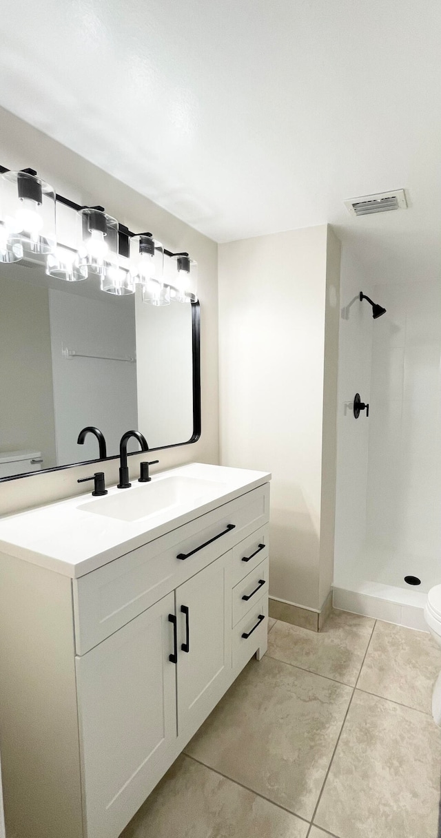 bathroom featuring vanity, toilet, walk in shower, and tile patterned flooring