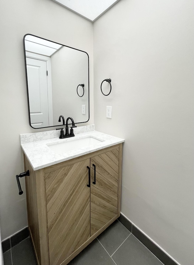 bathroom with tile patterned floors, baseboards, and vanity