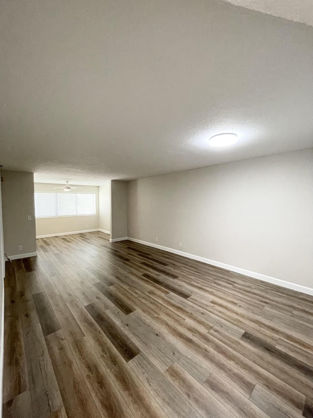 spare room featuring ceiling fan, a textured ceiling, baseboards, and wood finished floors