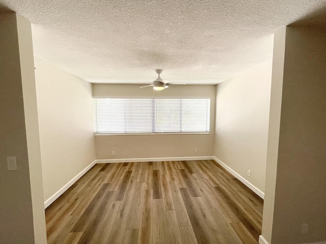 unfurnished room with a ceiling fan, wood finished floors, baseboards, and a textured ceiling