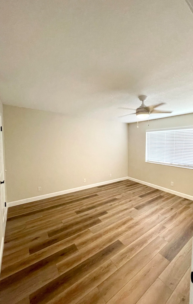 empty room with hardwood / wood-style flooring and ceiling fan