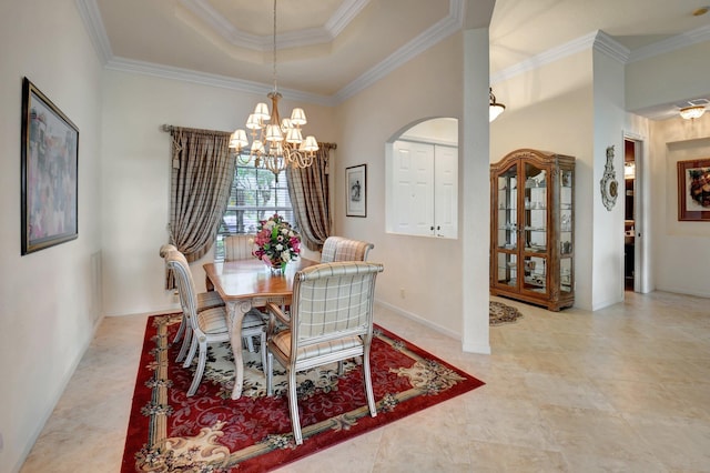 dining space with a raised ceiling, a notable chandelier, and ornamental molding