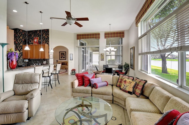 living room with ceiling fan with notable chandelier