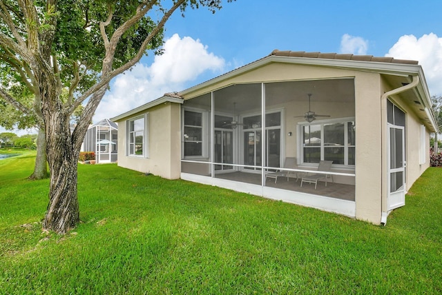 rear view of house featuring a sunroom and a lawn