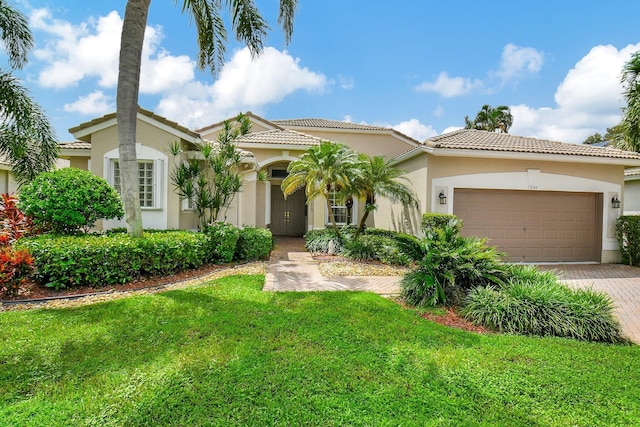 mediterranean / spanish house with a garage and a front yard