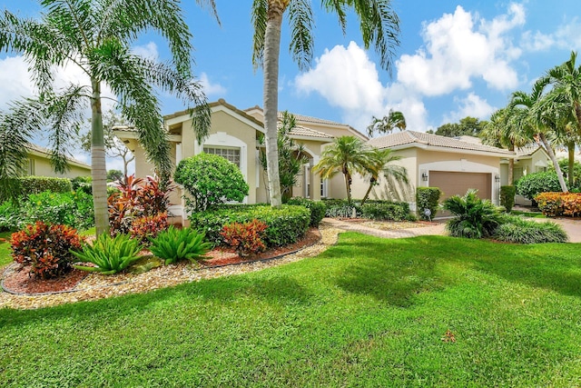 mediterranean / spanish home featuring a garage and a front lawn