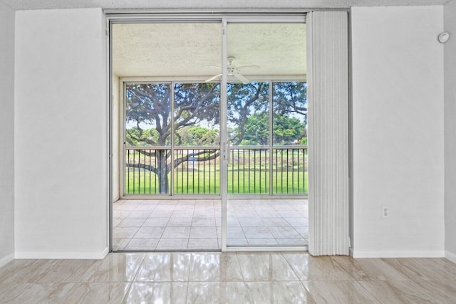 doorway to outside featuring a textured ceiling, floor to ceiling windows, and ceiling fan