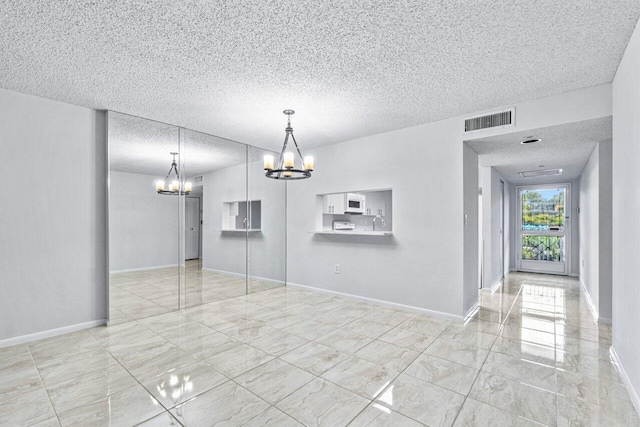 unfurnished dining area with a textured ceiling and an inviting chandelier