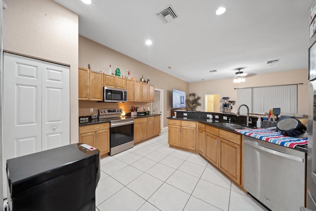 kitchen with appliances with stainless steel finishes, light tile patterned flooring, sink, and ceiling fan